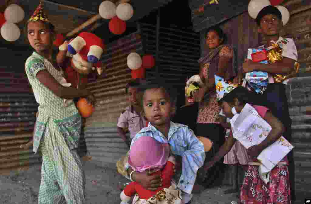 Indian slum children hold toys and gifts donated to them by a non-governmental organization as part of Christmas Day celebrations in Ahmadabad, Dec. 25, 2014.