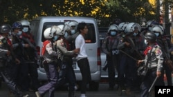 Police arrest a protester during a demonstration against the military coup in Yangon on February 26, 2021. (Photo by STR / AFP)