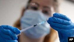 A nurse prepares a shot of the Pfizer-BioNTech COVID-19 vaccine at Guy's Hospital in London, Tuesday, Dec. 8, 2020