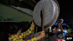 People clatter pans and tins to make noise to protest the military coup in response to a social media campaign in Yangon on February 2, 2021, as the party of Myanmar's toppled leader Aung San Suu Kyi demanded her immediate release Tuesday. (Photo by STR /