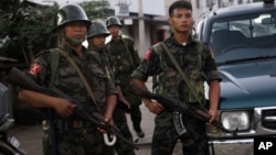 Soldiers from the Kachin Independence Army (KIA) stand on a road as they provide security in Laiza, a border town of China and Myanmar, Kachin State, Myanmar, Monday, Oct. 28, 2013. From 1961 until 1994, the KIA fought a grueling and inconclusive war against the Burmese junta fo