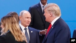 Prezidan Donald Trump (adwat) avèk Prezidan Larisi a, Vladimir Putin (mitan). Foto Dosye.