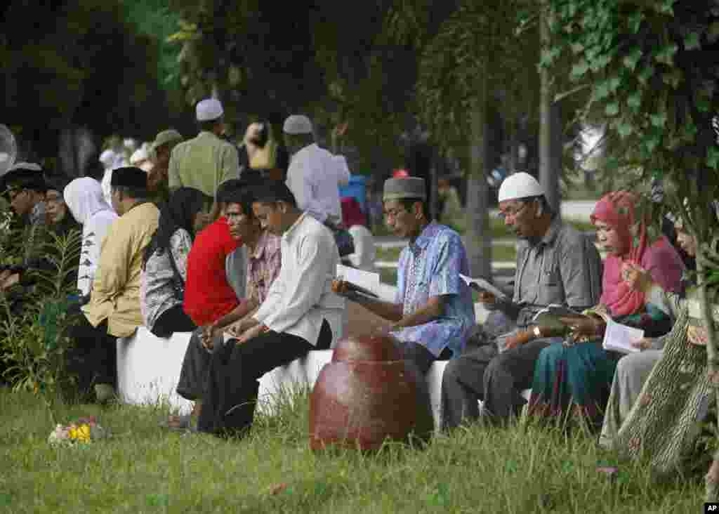 Acehnese read the Quran at a mass grave during the 10th anniversary of the tsunami in Siron, Aceh Besar, Indonesia, Friday, Dec 26, 2014.