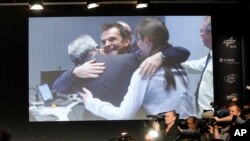 Celebrating scientists in the main control room appear on a video screen at the European Space Agency after the first unmanned spacecraft Philae landed on a comet called 67P/Churyumov-Gerasimenko, in Darmstadt, Germany, Nov. 12, 2014.