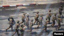 Army officers intervene during a protest against the military coup in Yangon, Myanmar, March 2, 2021. Picture taken from behind a window. REUTERS/Stringer