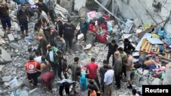 Palestinians search for casualties at the site of Israeli strikes on houses in Jabalia refugee camp at the Indonesian hospital, in the northern Gaza Strip