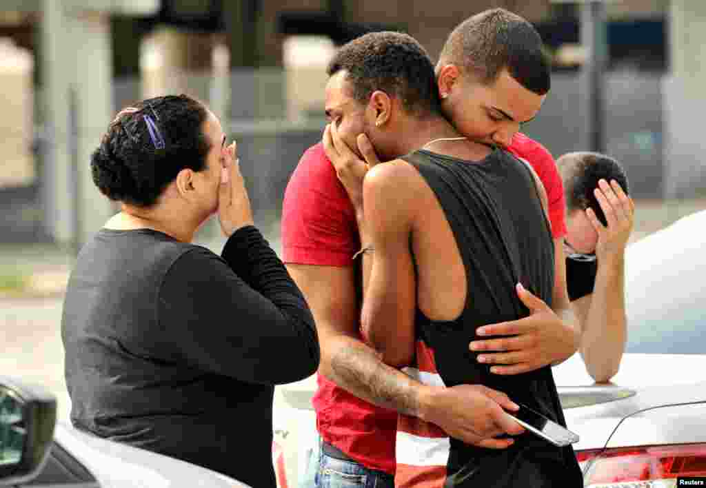 Friends and family members embrace outside the Orlando Police Headquarters during the investigation of a shooting at the Pulse night club, in Orlando, Florida, June 12, 2016. 