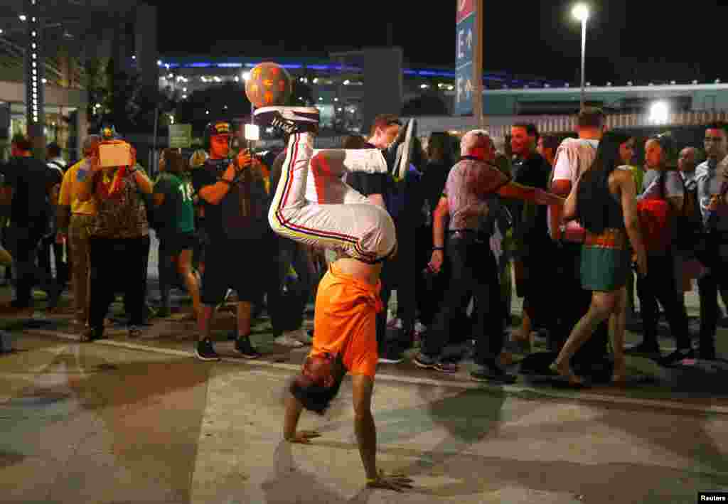 A Colombian performs tricks with a ball outside Maracana Stadium ahead of the opening ceremonies for the 2016 Summer Olympics in Rio de Janeiro, Brazil, Aug. 5, 2016.