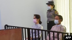 This handout photo taken on May 24, 2021 and released by Myanmar's Ministry of Information on May 26 shows detained civilian leader Aung San Suu Kyi (L) and detained president Win Myint (R) during their first court appearance in Naypyidaw, since the milit