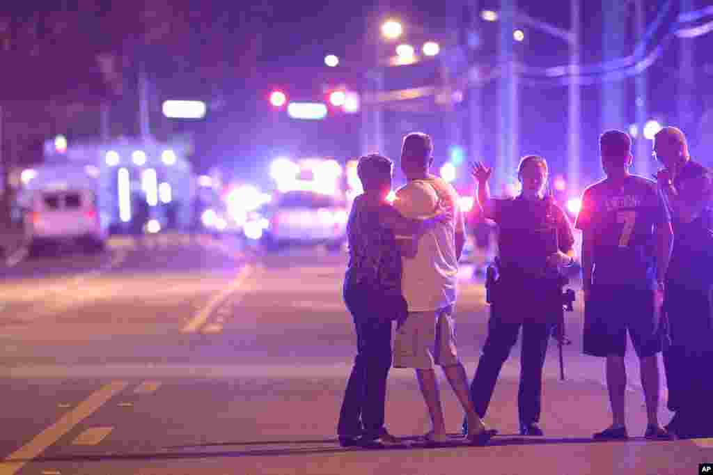 Orlando Police officers direct family members away from a multiple shooting at a nightclub in Orlando, Fla., Sunday, June 12, 2016. A gunman opened fire at a nightclub in central Florida, and multiple people have been wounded, police said Sunday. 