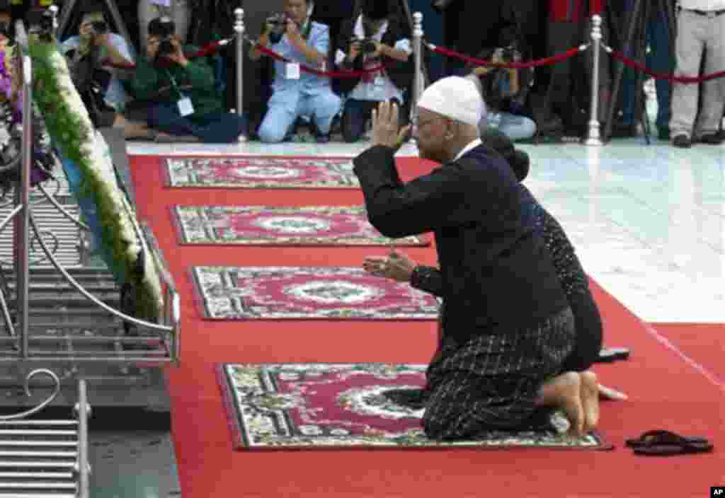 Aung San Oo, elder brother of Myanmar opposition leader Aung San Suu Kyi, and his wife Lei Lei Nwe Thein, pay respects after offering flowers at the tomb of his late father Gen. Aung San during a ceremony to mark the 68th anniversary of his 1947 assassina