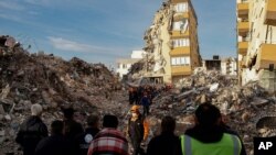 Local residents watch as members of rescue services work at collapsed buildings, destroyed in the Oct. 30 earthquake in Izmir, Turkey, Nov. 3, 2020. 