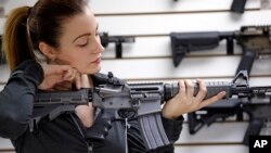 A gun shop owner demonstrates a Ruger AR-15 semi-automatic rifle, Nov. 7, 2017, in Lynnwood, Wash.