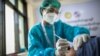 A health worker receives a vaccine for the Covid-19 coronavirus at the Ayeyarwady Covid Center in Yangon on January 27, 2021. (Photo by Sai Aung Main / AFP)