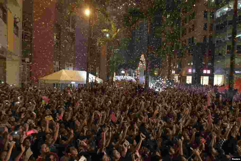 Confetti falls on revelers as they watch fireworks in the sky during New Year celebrations in Manila, Philippines, Jan. 1, 2015.