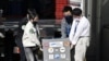 Japan Aerospace Exploration Agency's (JAXA) staff carry a case containing Hayabusa2's capsule with extensive samples of an asteroid as it arrives at JAXA Sagamihara Campus in Sagamihara in this photo taken by Kyodo, Dec. 8, 2020. 