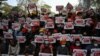 Protesters hold up signs supporting the Civil Disobedience Movement (CDM) at a demonstration against the military coup in Yangon on February 14, 2021. (Photo by YE AUNG THU / AFP)