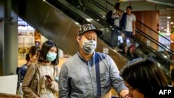 Passengers wearing face masks board their flight at Yangon International Airport on January 21, 2020. - China has confirmed human-to-human transmission in the outbreak of a new SARS-like virus as the number of cases soared and authorities January 21 said 