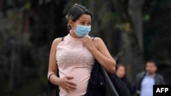 A pregnant woman wears a face mask as a preventive measure against the spread of the new coronavirus, COVID-19, as she waits for the bus in Bogota, on March 16, 2020. - The Colombian government announced the indefinite suspension of face-to-face classes i