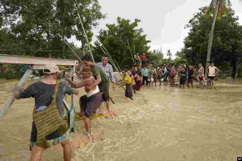 နေပြည်တော်အတွင်း တိုင်ဖွန်း Yagi (ရာဂီ) ကြောင့် ရေကြီးနေတဲ့နေရာက ကျိုးပျက်သွားတဲ့ တံတားစင်းပေါ် ကူးဖြတ်သွားလာနေသူများကိုတွေ့ရစဉ် (စက်တင်ဘာ ၁၇၊ ၂၀၂၄)