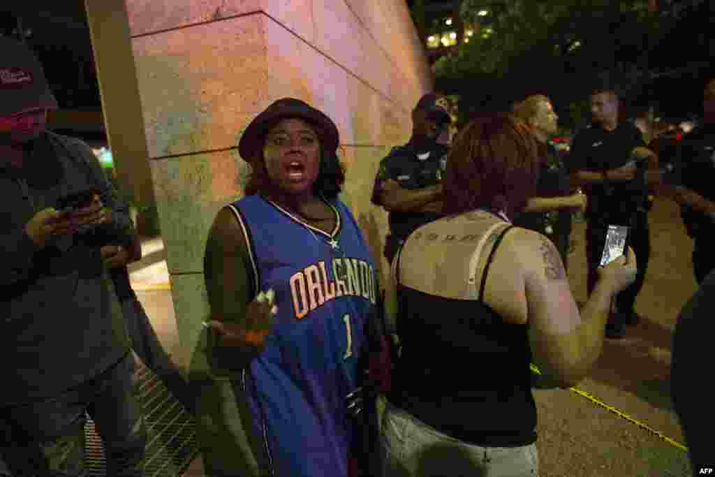 Protestors yell after police officers arrest a bystander following the shooting at a protest in Dallas on July 7, 2016.