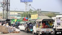 People flee the Hlaing Tharyar township in Yangon on March 16, 2021, as security forces continue a crackdown on protests in the area against the military coup. (Photo by STR / AFP)