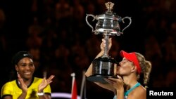 Germany's Angelique Kerber kisses the trophy after Kerber won their final match at the Australian Open tennis tournament at Melbourne Park, Australia, Jan. 30, 2016. 