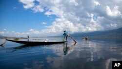 An ethnic Inntha fishermen on boats use their fishing net in Inlay lake, Nyaung Shwe township, southern Shan State, Myanmar, Wednesday, Oct. 1, 2014. 