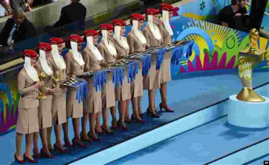 Hostesses hold the medals as they stand next to the World Cup trophy, right, after the World Cup final soccer match between Germany and Argentina at the Maracana Stadium in Rio de Janeiro, Brazil, Sunday, July 13, 2014. Mario Goetze volleyed in the winnin