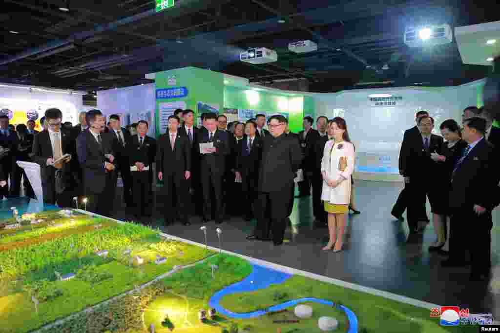 North Korean leader Kim Jong Un and his wife Ri Sol Ju look at an exhibition in Beijing as he pays an unofficial visit to China, in this undated photo released by North Korea&#39;s Korean Central News Agency (KCNA) in Pyongyang, March 28, 2018.