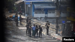 Army officers detain a man during a protest against the military coup in Yangon, Myanmar, March 2, 2021. Picture taken from behind a window. REUTERS/Stringer