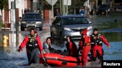 First responders pull local residents in a boat as they perform rescues of people trapped by floodwaters after the remnants of Tropical Storm Ida brought drenching rain, flash floods and tornadoes to parts of the northeast in Mamaroneck, New York, U.S., 