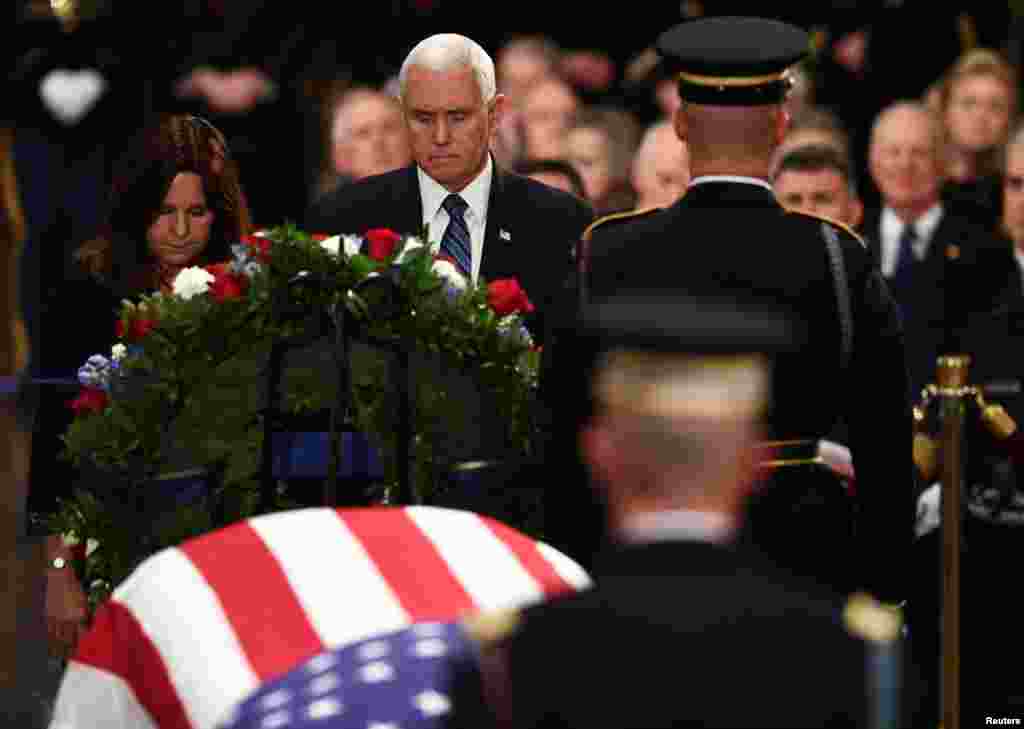 U.S. Vice President Mike Pence (C) and second lady of the United States Karen Pence (L) pay their respects at the casket bearing the remains of former U.S. President George H.W. Bush at the US Capitol during the State Funeral in Washington, D.C., Dec. 3, 2018.