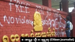 A student protester sprayed is seen spraying on the sign board of Yadanarbon University, Mandalay. July 26, 2015.