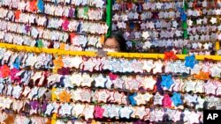 A woman hangs a paper note bearing her New Year wishes to a wire at a Buddhist temple in Seoul, South Korea.