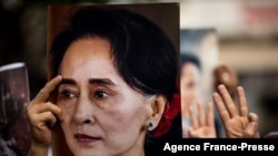 FILE - A protester holds a photo of detained Myanmar civilian leader Aung San Suu Kyi during a demonstration against the military coup outside the Myanmar Embassy in Bangkok on Feb. 7, 2021.