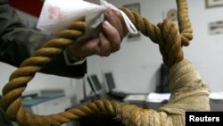 FILE - A museum worker shows a noose on display in a Iraqi museum in Baghdad, December 30, 2008.