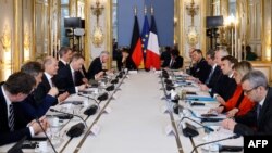 France's President Emmanuel Macron (R) and German Chancellor Olaf Scholz (L) attend a working session at the Elysee Palace in Paris, Jan. 22, 2023.