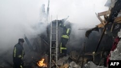 Ukrainian firefighters search a house following Russian shelling in the city of Kherson, Jan. 29, 2023,