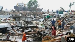 Residents search for their belongings amid the debis of their collapsed huts after the cyclone Sitrang hits in Chittagong, Bangladesh, Oct. 25, 2022.