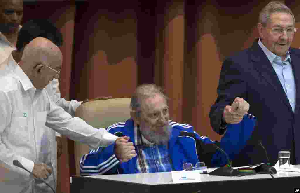 Fidel Castro sits as he clasps hands with his brother, Cuban President Raul Castro, right, and second secretary of the Central Committee, Jose Ramon Machado Ventura, moments before the playing of the Communist party hymn during the closing ceremonies of the 7th Congress of the Cuban Communist Party, in Havana, Cuba, Tuesday, April 19, 2016.