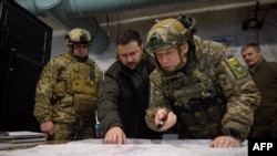 TOPSHOT - This handout photograph taken and released by the Ukrainian Presidential Press Service on November 30, 2023 shows Ukrainian President Volodymyr Zelensky (C-L) and Colonel General Oleksandr Syrskyi (C-R) visiting of Ukraine's army command post in