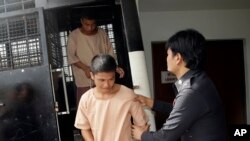 Myanmar migrant workers Zaw Lin, front left, and Win Zaw Htun, rear, arrive at a provincial court in Surat Thani province, Thailand Wednesday, July 8, 2015. 