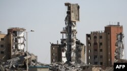 Buildings which were destroyed in previous Israeli bombardments stand in Nuseirat in the central Gaza Strip, on April 1, 2024, amid the ongoing battles Israel and the Hamas militant group.