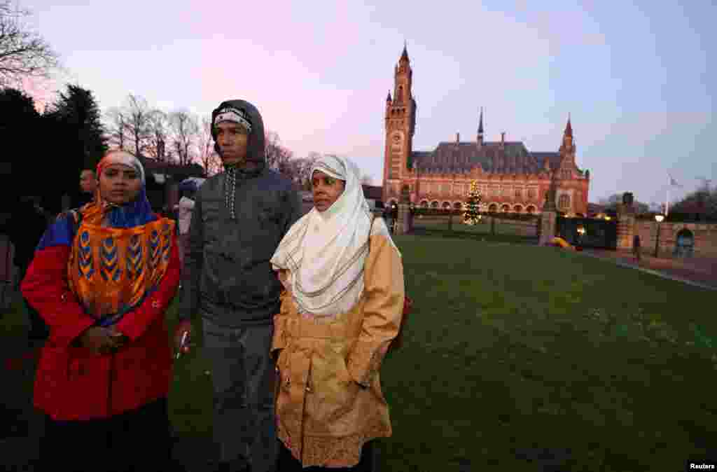 Rohingya survivors stand outside the International Court of Justice (ICJ), ahead of hearings in a case filed by Gambia against Myanmar alleging genocide against the minority Muslim Rohingya population, in The Hague, Netherlands December 10, 2019. REUTERS