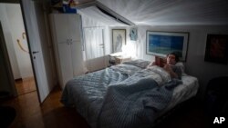 Doctor Giovanni Passeri reads a book in the garret of his apartment before getting some sleep at the end of his day in the COVID-19 section of the Maggiore Hospital in Parma, northern Italy Wednesday, April 7, 2020. Passeri, who implemented his own…