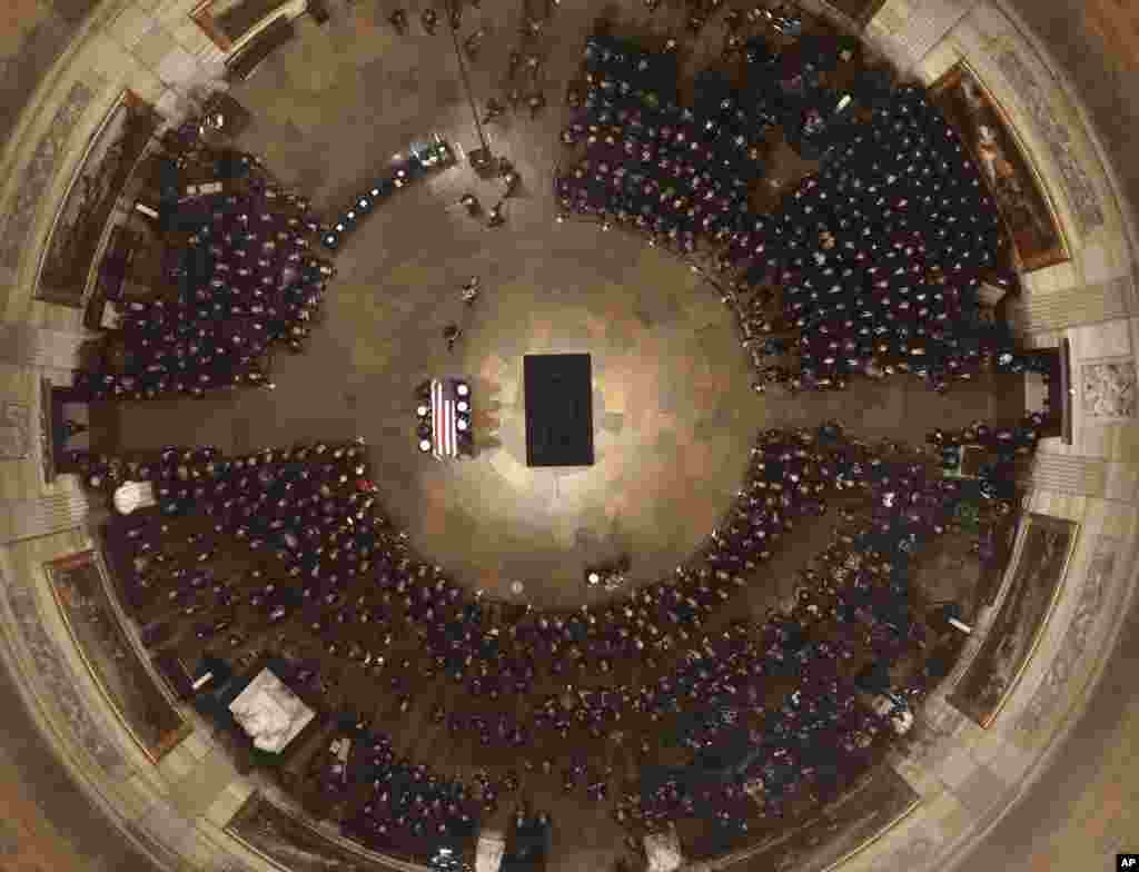 The flag-draped casket of former President George H.W. Bush is carried by a joint services military honor guard into the U.S. Capitol Rotunda, Dec. 3, 2018, in Washington.