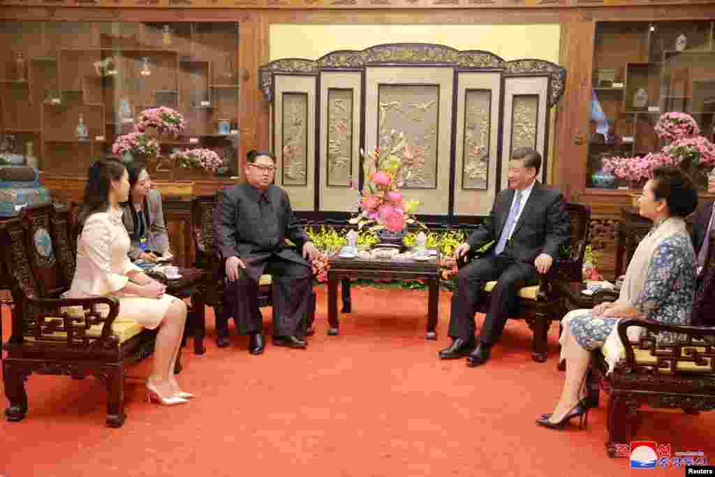 North Korean leader Kim Jong Un and wife Ri Sol Ju, and Chinese President Xi Jinping and wife Peng Liyuan meet in Beijing, China, in this undated photo released by North Korea&#39;s Korean Central News Agency (KCNA) in Pyongyang, March 28, 2018.