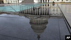 The U.S. Capitol is seen reflected after rain in Washington, Dec. 21, 2018.
