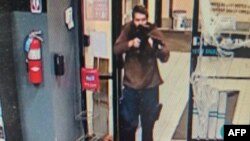 This handout image released on October 25, 2023 by the Androscoggin County Sheriff's Office via Facebook shows the armed suspect in a shooting as law enforcement in Androscoggin County investigate "two active shooter events" in Lewiston, Maine.